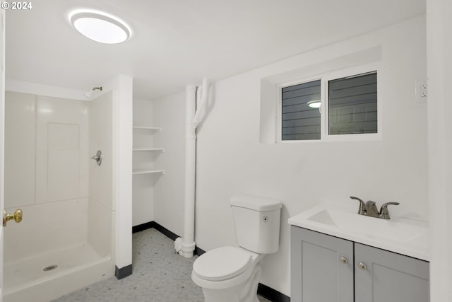 bathroom featuring toilet, walk in shower, and vanity