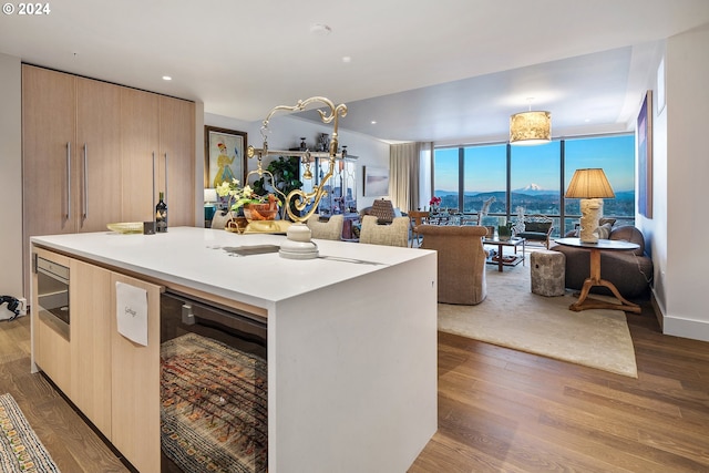 kitchen with expansive windows, beverage cooler, open floor plan, and wood finished floors