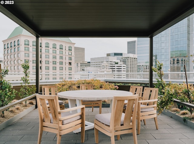 balcony with outdoor dining area and a city view