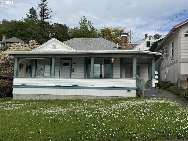 view of front of house featuring covered porch and a front yard