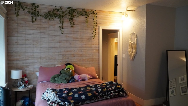 bedroom featuring wood walls