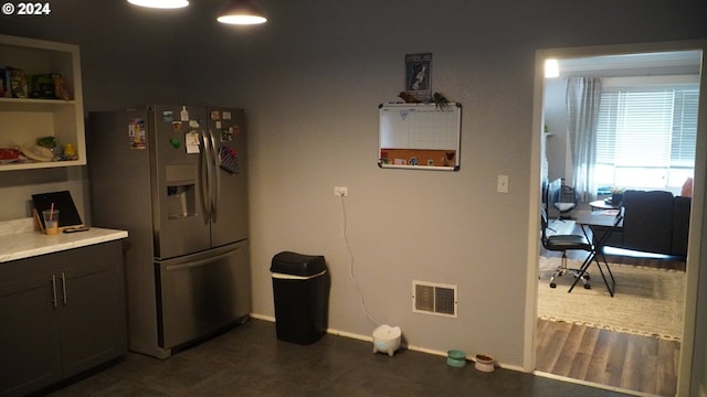 kitchen featuring dark wood-type flooring, dark brown cabinetry, and stainless steel fridge