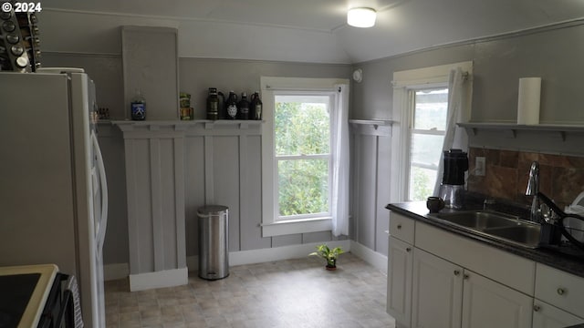 kitchen featuring vaulted ceiling, sink, white cabinets, white refrigerator, and range