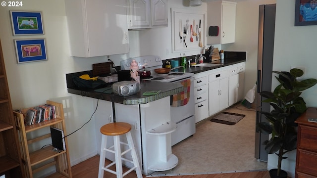 kitchen with sink, white cabinets, and white range with electric stovetop