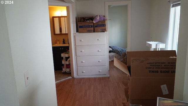 bedroom with ensuite bath and hardwood / wood-style floors