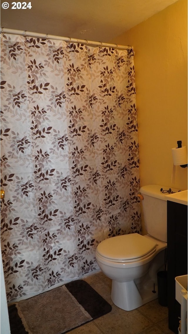 bathroom with toilet and tile patterned flooring