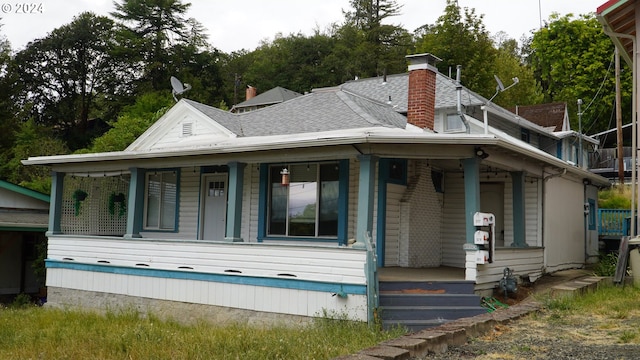 back of property featuring covered porch