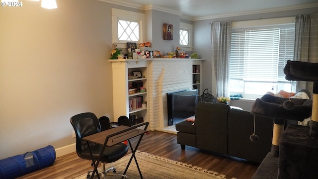 living room featuring a healthy amount of sunlight, dark hardwood / wood-style floors, and a brick fireplace