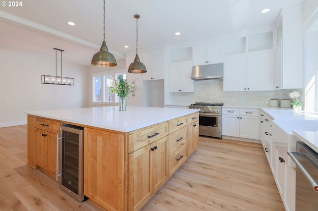 kitchen with light hardwood / wood-style floors, white cabinetry, stainless steel appliances, and wine cooler