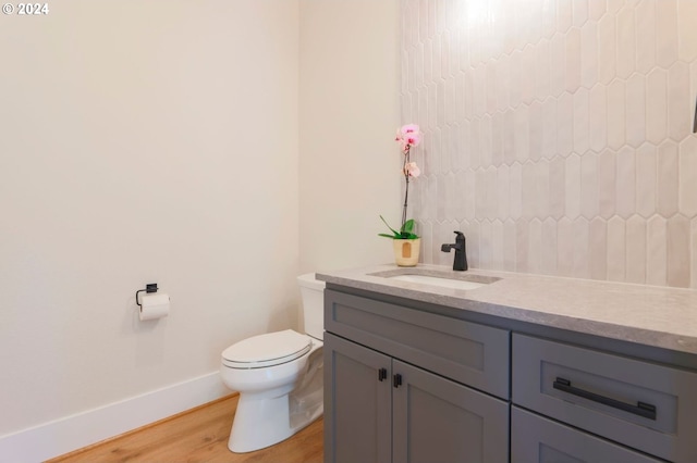 bathroom with hardwood / wood-style flooring, vanity, and toilet