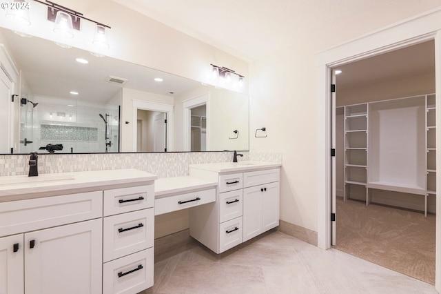 bathroom featuring tile patterned flooring, vanity, a shower with door, and backsplash