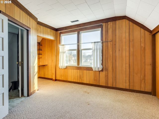 bonus room with lofted ceiling and light colored carpet