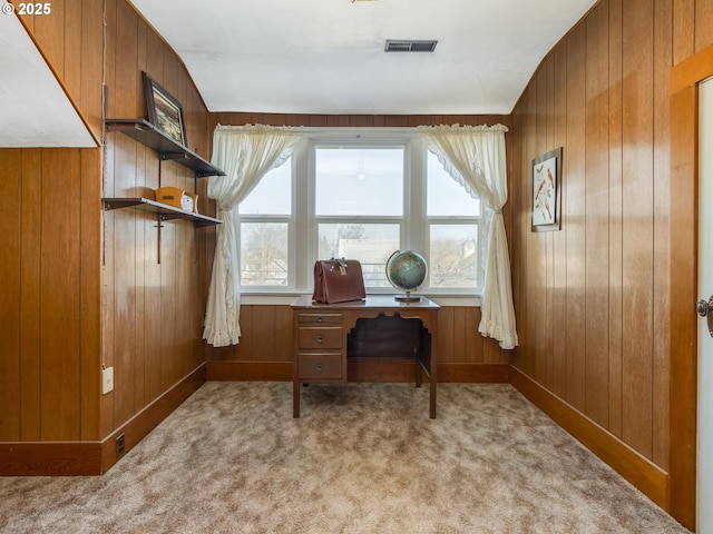 office featuring light carpet and wood walls