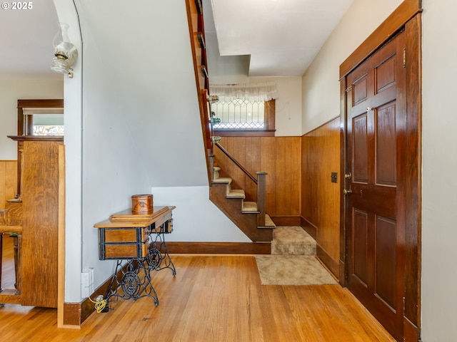 entryway featuring light hardwood / wood-style flooring and wooden walls