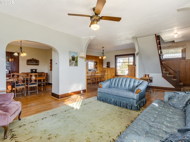 living room featuring ceiling fan with notable chandelier and hardwood / wood-style floors