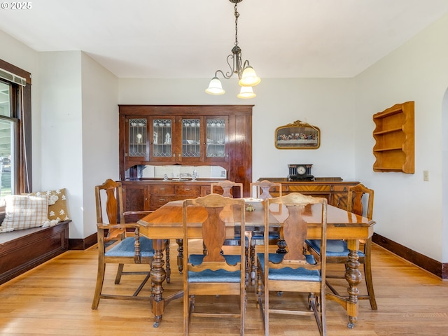 dining area featuring light hardwood / wood-style flooring and an inviting chandelier