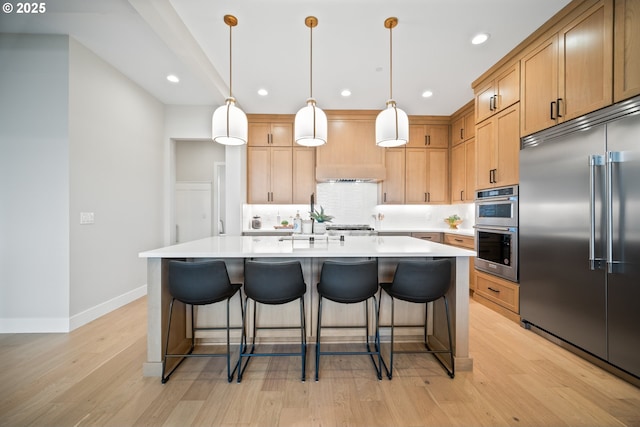 1669 NW Goodwin St, Camas, WA 98607 - kitchen with appliances with stainless steel finishes, light wood-type flooring, backsplash, light countertops, and recessed lighting