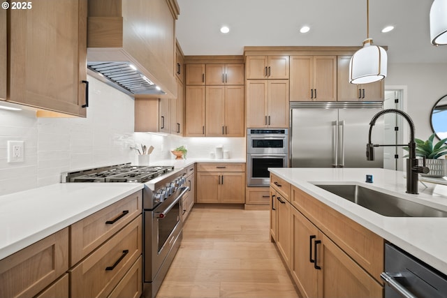 1669 NW Goodwin St, Camas, WA 98607 - kitchen with high quality appliances, a sink, premium range hood, backsplash, and light wood-style flooring