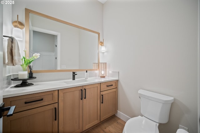 1669 NW Goodwin St, Camas, WA 98607 - bathroom featuring toilet, vanity, wood finished floors, baseboards, and backsplash