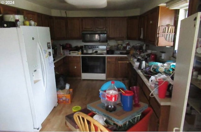 kitchen with light hardwood / wood-style floors and white appliances