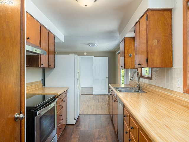 kitchen featuring stainless steel appliances, sink, tasteful backsplash, and dark hardwood / wood-style flooring