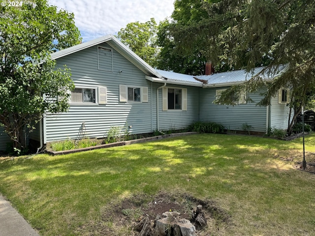 view of home's exterior featuring metal roof and a yard