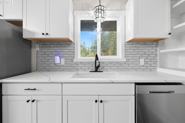 kitchen with white cabinetry, sink, hanging light fixtures, stainless steel dishwasher, and light stone countertops