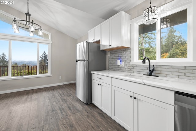 kitchen with appliances with stainless steel finishes, sink, pendant lighting, and white cabinets