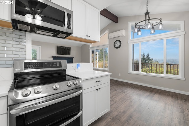 kitchen featuring white cabinetry, light stone counters, a wall unit AC, and stainless steel appliances