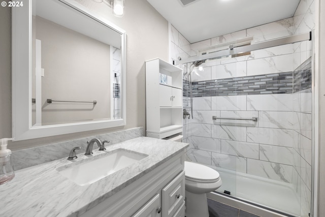 bathroom featuring vanity, an enclosed shower, and toilet