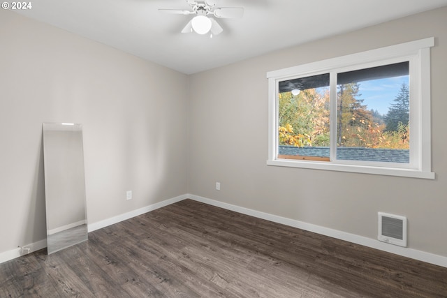 empty room with ceiling fan and dark hardwood / wood-style flooring