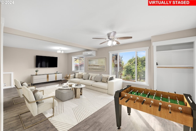 recreation room with ceiling fan, hardwood / wood-style floors, and an AC wall unit