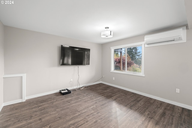 spare room with an AC wall unit and dark hardwood / wood-style flooring