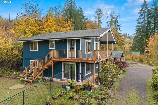 rear view of property with a deck and a lawn