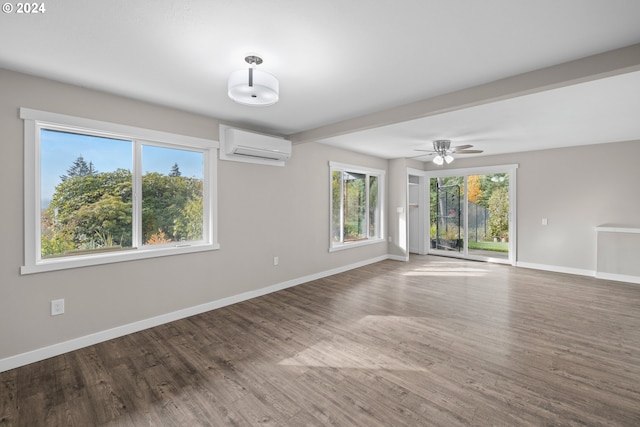 empty room featuring hardwood / wood-style flooring, an AC wall unit, and ceiling fan