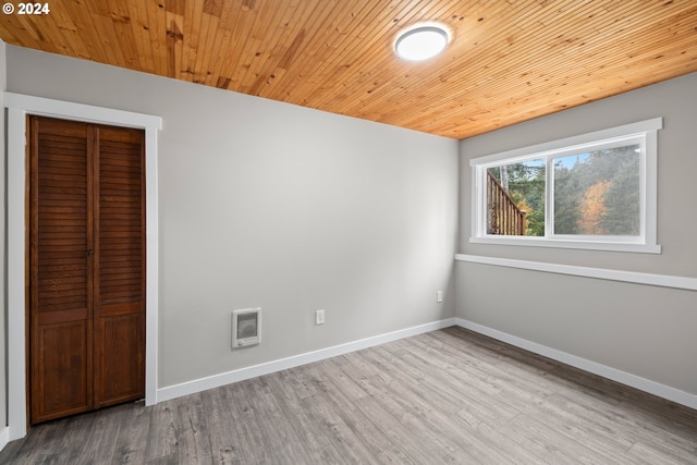 interior space featuring wood ceiling, heating unit, and light wood-type flooring