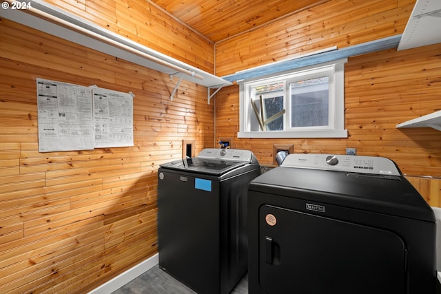 washroom with wooden walls and washing machine and dryer