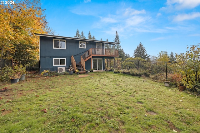 rear view of property with a wooden deck and a yard