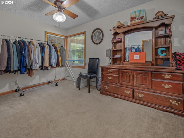 carpeted office space with a textured ceiling and ceiling fan