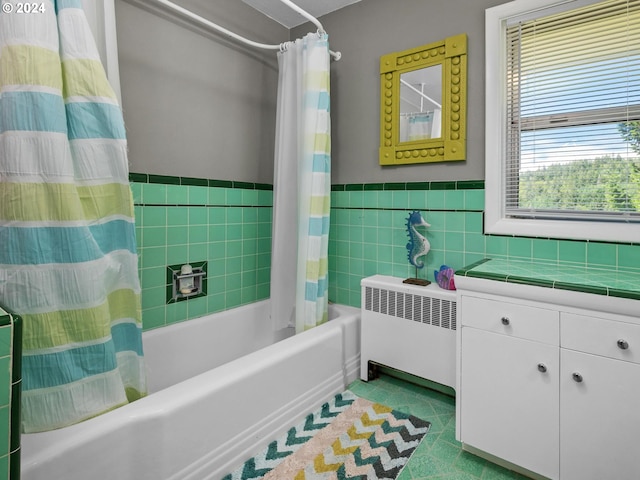 bathroom featuring tile patterned flooring, radiator heating unit, shower / bathtub combination with curtain, and tile walls