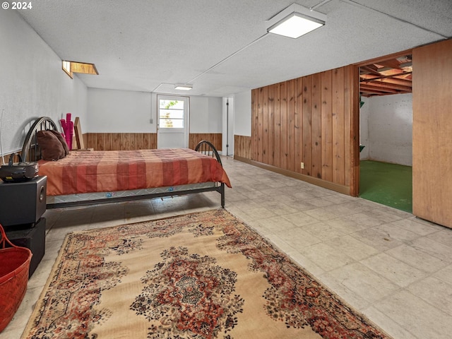 bedroom featuring a textured ceiling and wooden walls