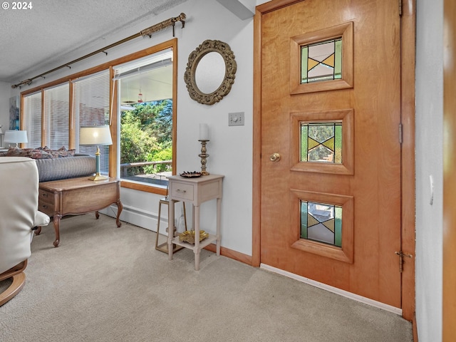 carpeted foyer entrance with a textured ceiling