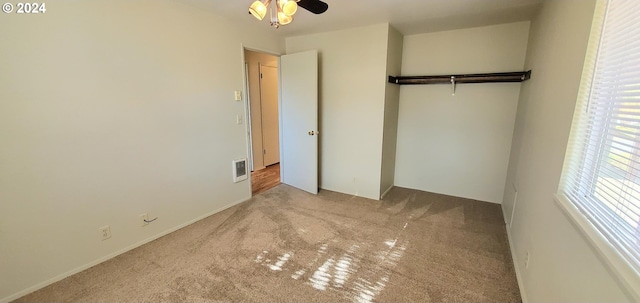 unfurnished bedroom featuring light colored carpet, a closet, and ceiling fan