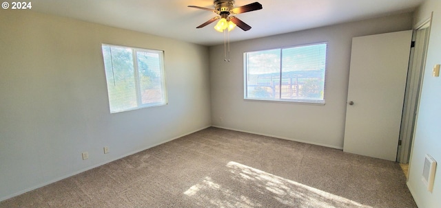 carpeted empty room with a healthy amount of sunlight and ceiling fan