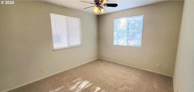 carpeted spare room with ceiling fan