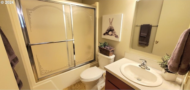 full bathroom featuring vanity, combined bath / shower with glass door, and toilet