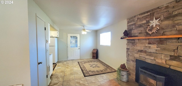 doorway with ceiling fan and a fireplace