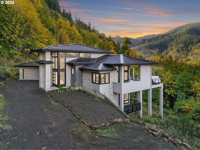 view of front of property featuring a balcony and a mountain view