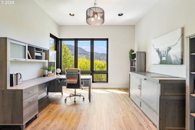 office area with built in desk, light hardwood / wood-style flooring, and a mountain view