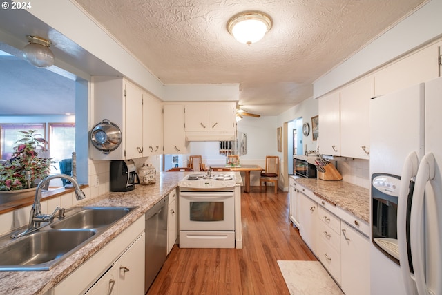 kitchen with white cabinetry, sink, a textured ceiling, white appliances, and light wood-type flooring